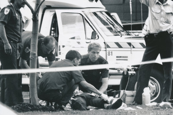 Wounded policeman Warren Treloar receives emergency treatment  after being shot in the chest and shoulder.