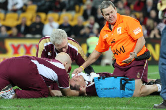 Queensland medical staff attend to Steve Price after he is rocked by Brett White.