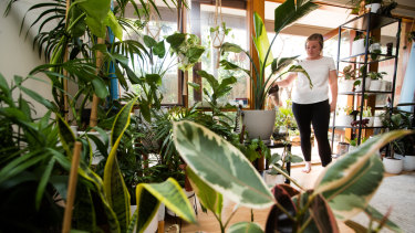 Rachel Okell waters one of 70 indoor plants at her home. 