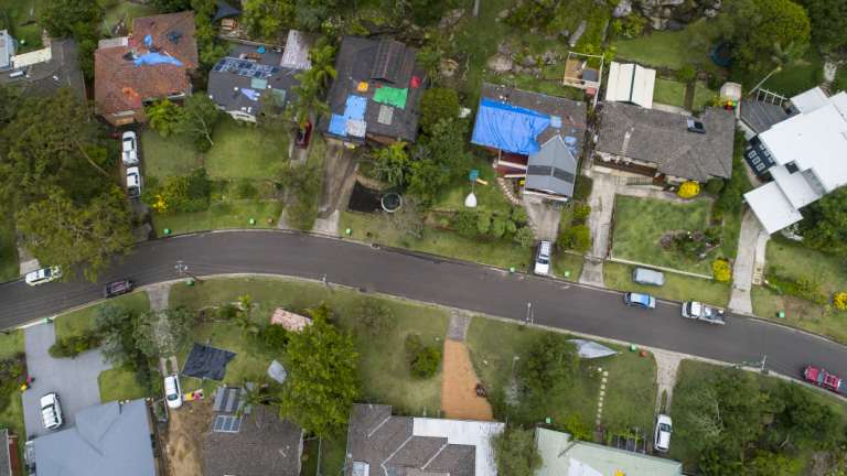 Many homes in Berowra Heights had their roofs covered in tarpaulins on Friday. 