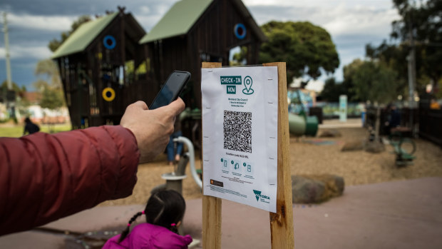 A parent uses a QR code check at a playground in Brunswick.