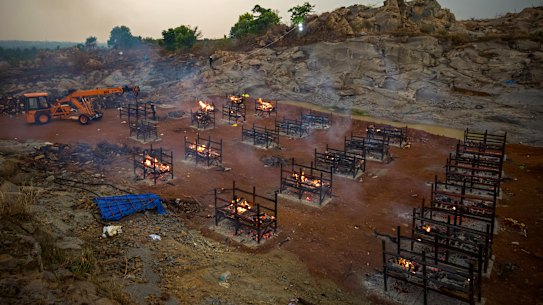 BENGALURU, INDIA - APRIL 30: A crane places new biers in a disused granite quarry repurposed to cremate the dead due to COVID-19 on April 30, 2021 in Bengaluru, India. With recorded cases crossing 380,000 a day and 3000 deaths in the last 24 hours, India has more than 2 million active cases of COVID-19, the second-highest number in the world after the U.S. A new wave of the pandemic has totally overwhelmed the country’s healthcare services and has caused crematoriums to operate day and night as the number of victims continues to spiral out of control. (Photo by Abhishek Chinnappa/Getty Images)