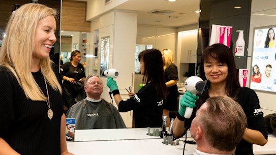 JustCuts CEO Amber Manning watches as regular customer, Robert Elder, gets a haircut in Randwick, Sydney.