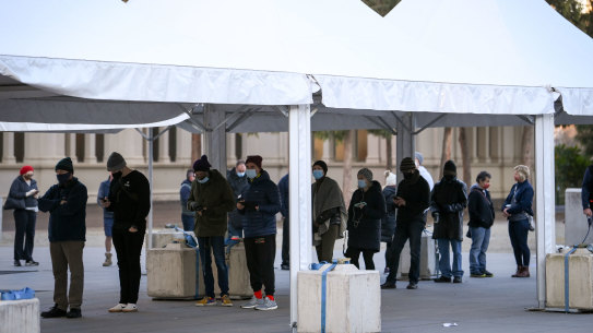 People queue to receive the COVID-19 vaccine at the vaccination hub at the Royal Exhibition Building in Carlton.