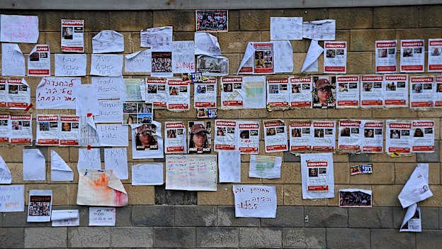 Posters of the faces of Israeli hostages taken by Hamas on October 7 and signs on a wall in Tel Aviv, Israel.