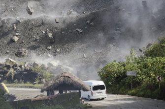 Boulders fall as a vehicle negotiates a road during an earthquake in Bauko, Mountain Province, Philippines on Wednesday.