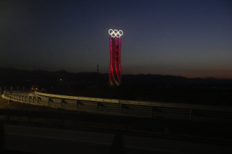 The Olympic rings are lit up along a road at the 2022 Winter Olympics in the Yanqing district of Beijing.