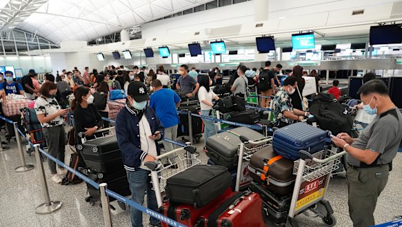 People queue up to check in for flights to the UK at Hong Kong airport in June. Having to prove you’ve been vaccinated and tested means it might take longer to get to where you’re going.