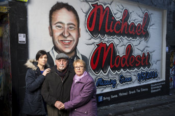 Much loved: Gisella Hardy, left, and her parents Marcello and Gail at the Hosier Lane mural of their brother and son, Michael Modesti, who has been missing for two years.