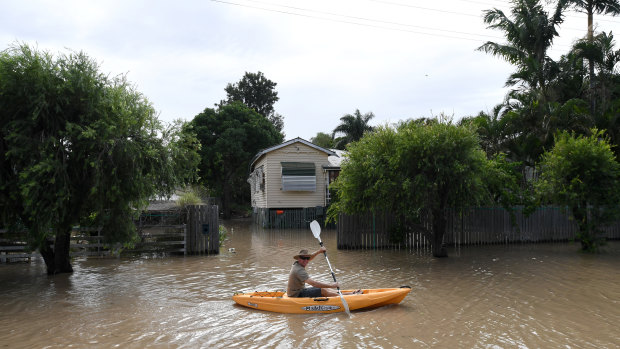 A local resident pedals his kayak through flooded streets in Rockhampton, during the aftermath of Cyclone Debbie.