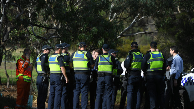 Uniformed police, detectives and members of the State Emergency Service at the scene in Parkville where a woman's body was found on Saturday morning.