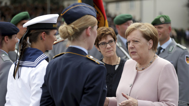 German Chancellor Angela Merkel, right, and Defence Minister Annegret Kramp-Karrenbauer, centre, talk to soldiers in Berlin.