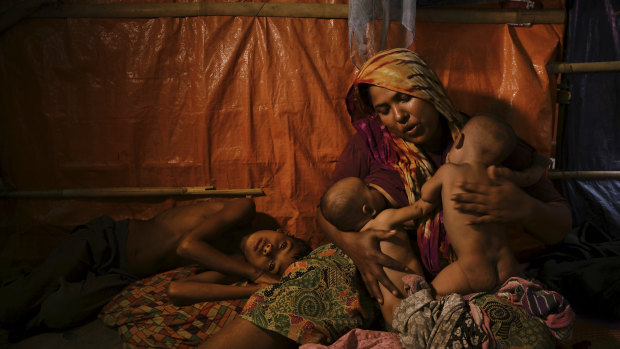 Rohingya woman Fatima Begum comforts her twins Asia and Rubina as her sick son Sadeka lays by her side at the Balukhali camp in Bangladesh.