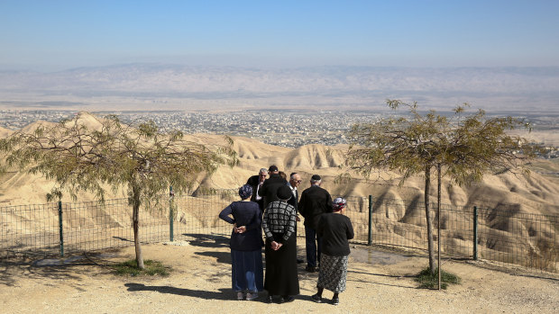 Jewish settlers stand at a view point overlooking the West Bank city of Jericho which will be left almost an island if Israel annexes the Jordan Valley as planned.