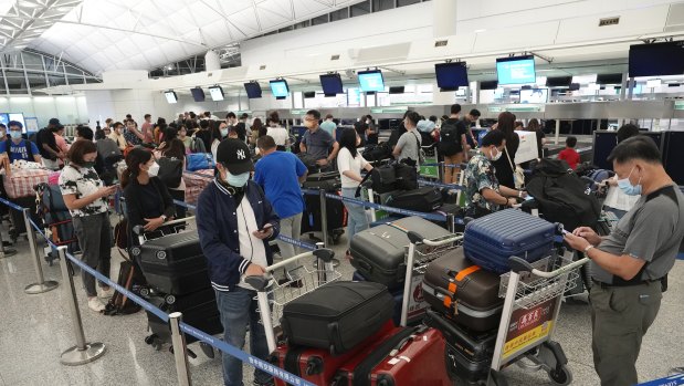 People queue up to check in for flights to the UK at Hong Kong airport in June. Having to prove you’ve been vaccinated and tested means it might take longer to get to where you’re going.