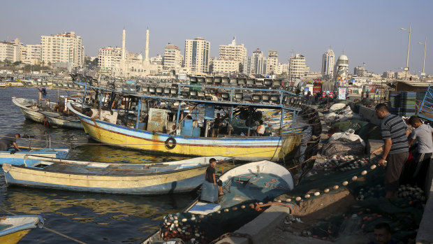 Palestinian fishermen repair their nets in Gaza City. On Tuesday Israel said it was tightening its naval blockade to limit Palestinians from sailing beyond three nautical miles off Gaza's coast, from six nautical miles previously.