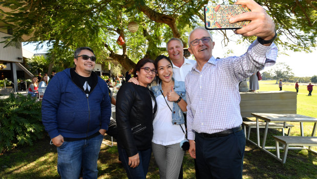 Prime Minister Malcolm Turnbull poses for a selfie photograph with people at the Sandstone Point Hotel in Longman on Friday.