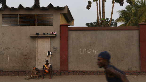 A man and a boy watch a game of soccer on the streets of the Democratic Republic of Congo’s capital Kinshasa. 