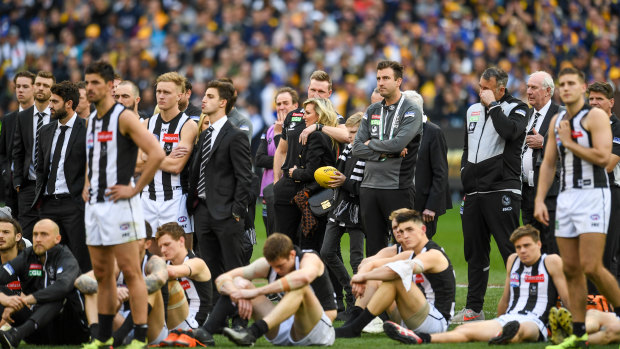 Dejected Collingwood players watch th presentations after the 2018 AFL grand final.