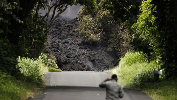 US Air Force Lieutenant Colonel Chuck Anthony walks towards a wall of lava entering the ocean near Pahoa, Hawaii on Sunday,