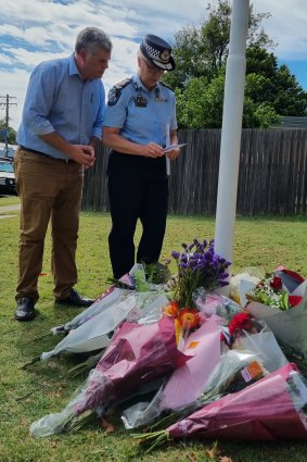 Queensland Police Minister Mark Ryan and Queensland Police Commissioner Katarina Carroll look at flowers left at Chinchilla Police Station.