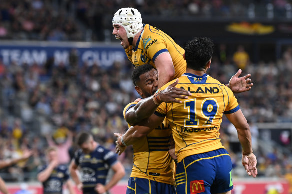 Maika Sivo celebrates a try with teammates Bailey Simonsson and Reed Mahoney.