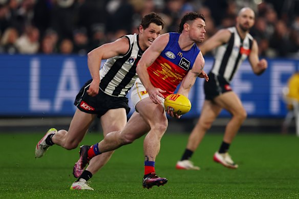 Lachie Neale of the Lions handballs.