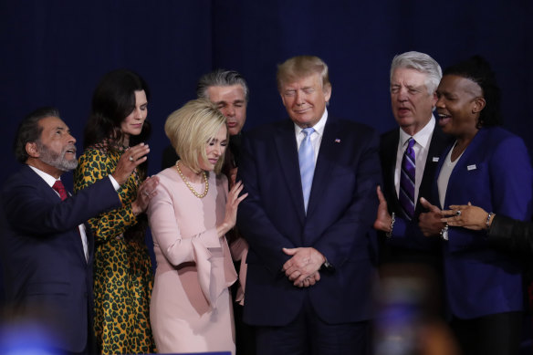 İnanç liderleri, 2020'de Miami'deki Kral İsa Uluslararası Bakanlık kilisesinde evanjelik destekçileri için yapılan bir miting sırasında dönemin başkanı Donald Trump ile dua ediyor. 2016'da Trump'ın Beyaz Saray'a gönderilmesine yardım eden muhafazakar evanjelik Hıristiyanlar, 2020'de yine ona yapıştı.