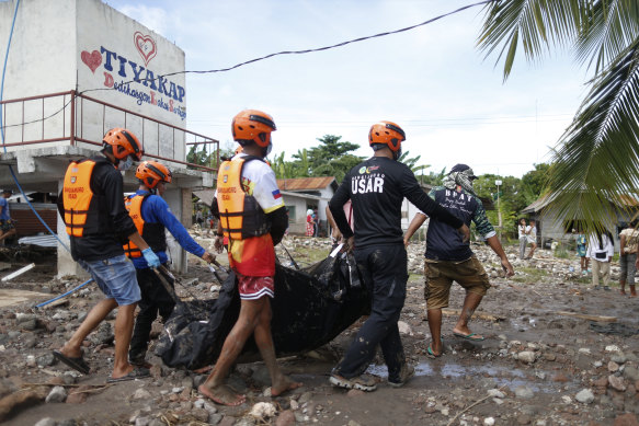 Rescuers carry a body which they retrieved after Tropical Storm Nalgae hit Maguindanao’s Datu Odin Sinsuat town, southern Philippines.