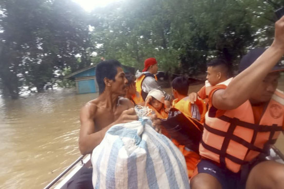 Rescuers use boats to evacuate residents from areas flooded by Tropical Storm Nalgae in the Philippines.