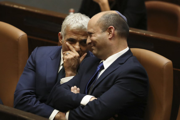 Israel’s new Prime Minister Naftali Bennett, right, sits with Yair Lapid during a Knesset vote to oust Netanyahu. Bennett will serve for the first two years and Lapid for the next two of the unity government’s term.