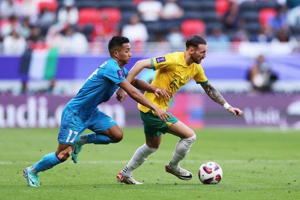 Martin Boyle runs with the ball while under pressure from Lallianzuala Chhangte of India during the Asian Cup opener.