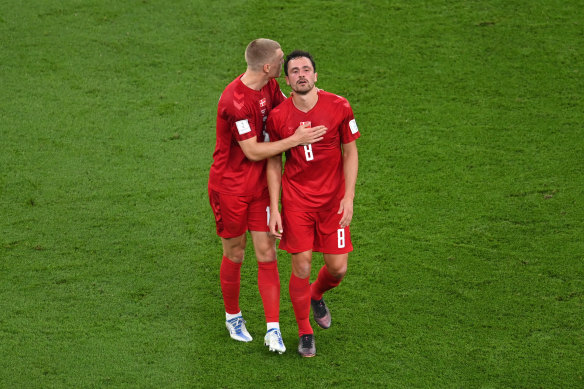 Danish player Rasmus Kristensen consoles Thomas Delaney during the match against Tunisia wearing the subdued Hummel jersey.