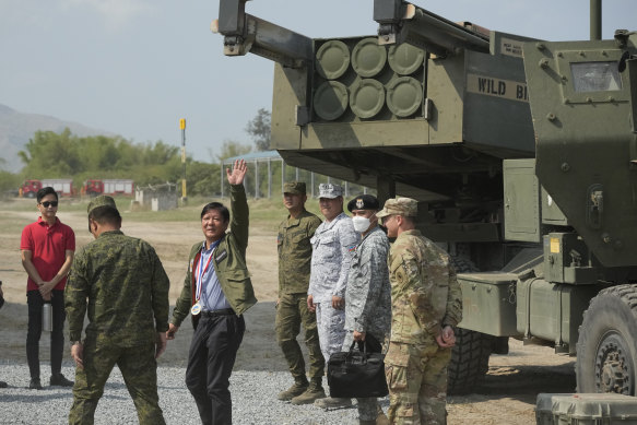 Philippine President Ferdinand Marcos jnr waves beside a US M142 high mobility artillery rocket system at the drills on Wednesday.