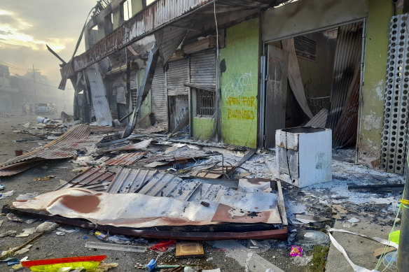 Çin Mahallesi, Honiara ve Solomon Adaları'nda Kasım 2021'deki ayaklanmaların ardından hasarlı dükkanların dışında sokakta enkaz yatıyor. 