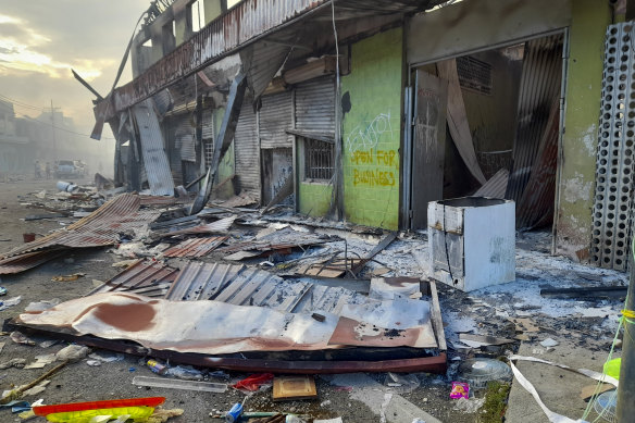 Debris lies on the street outside damaged shops in Chinatown, Honiara, Solomon Islands after riots in November 2021. 