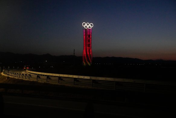 The Olympic rings are lit up along a road at the 2022 Winter Olympics in the Yanqing district of Beijing.