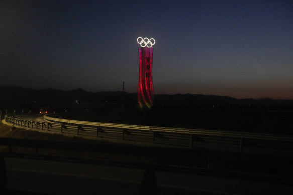 The Olympic rings are lit up along a road at the 2022 Winter Olympics in the Yanqing district of Beijing.