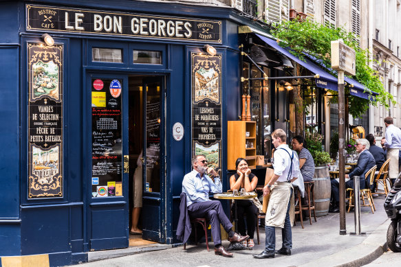 İnsanlar Paris'te bir kafede yiyecek ve içeceklerin tadını çıkarıyor.  Birçok ülke gibi Fransa da pandemiden sonra insanları, özellikle de gençleri işe geri dönmeye ikna etmekte zorlanıyor.