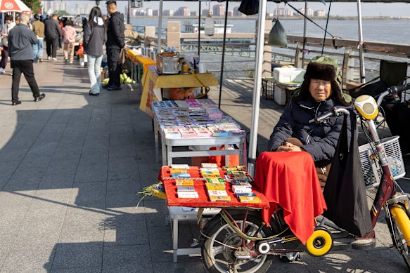 A vendor sells smuggled North Korean cigarettes and banknotes along the riverfront in Dandong.
