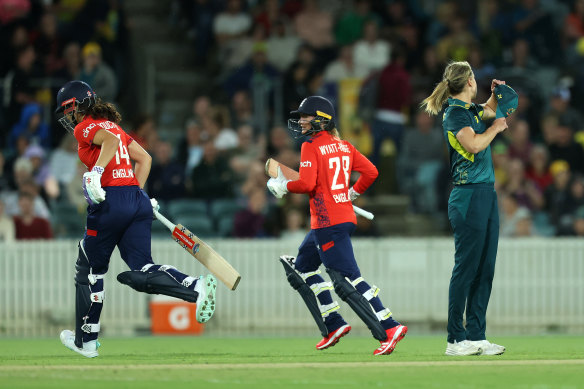Sophia Dunkley of England and Danni Wyatt-Hodge of England run off the field after lightning strikes as Ellyse Perry of Australia