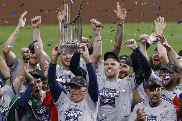 Brian Snitker hoists the trophy as Atlanta celebrate their World Series win.