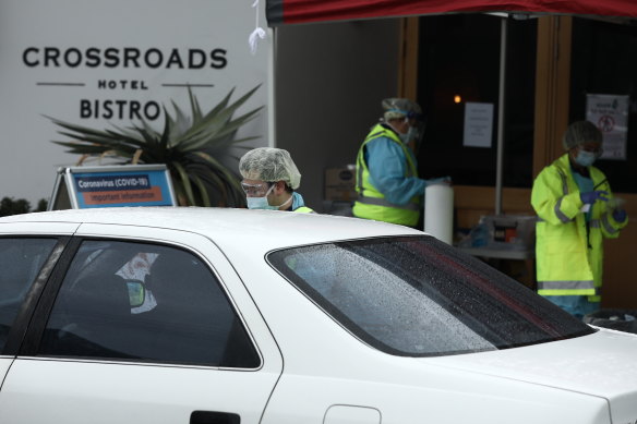 Medical staff at a pop-up COVID-19 testing clinic perform tests outside the Crossroads Hotel in Casula over the weekend.