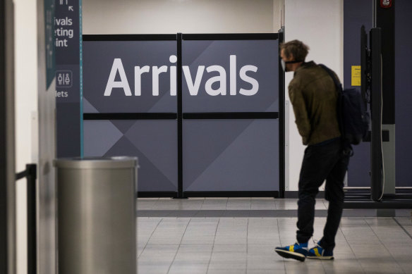 A traveller, wearing a protective face mask, passes through the arrivals area after landing at London Luton Airport on Friday.