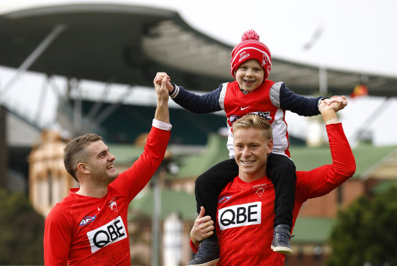 Swans Tom Papley and Isaac Heeney with Isaac Bate, 5, who was named after Heeney.