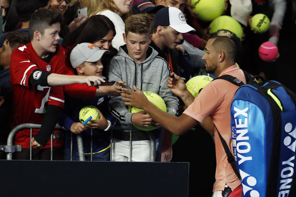 Nick Kyrgios signs autographs for fans after winning his first round match against Lorenzo Sonego/