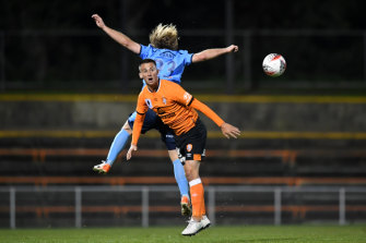 Brisbane Roar's Jordan Courtney-Perkins  competes for the ball with Rhyan Grant of Sydney FC.