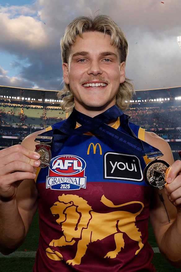 Father-son Lion Will Ashcroft holds his Norm Smith Medal and his premiership medal after the 2025 flag win.
