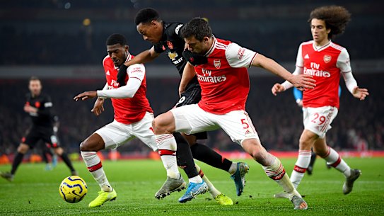 Manchester United's Anthony Martial (centre) is challenged by Arsenal duo Ainsley Maitland-Niles (left) and goalscorer Sokratis Papastathopoulos.