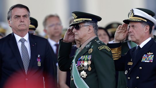 Brazil’s President Jair Bolsonaro, left, receives military honours in 2019.